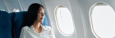 egy repülőgépen alvó nő