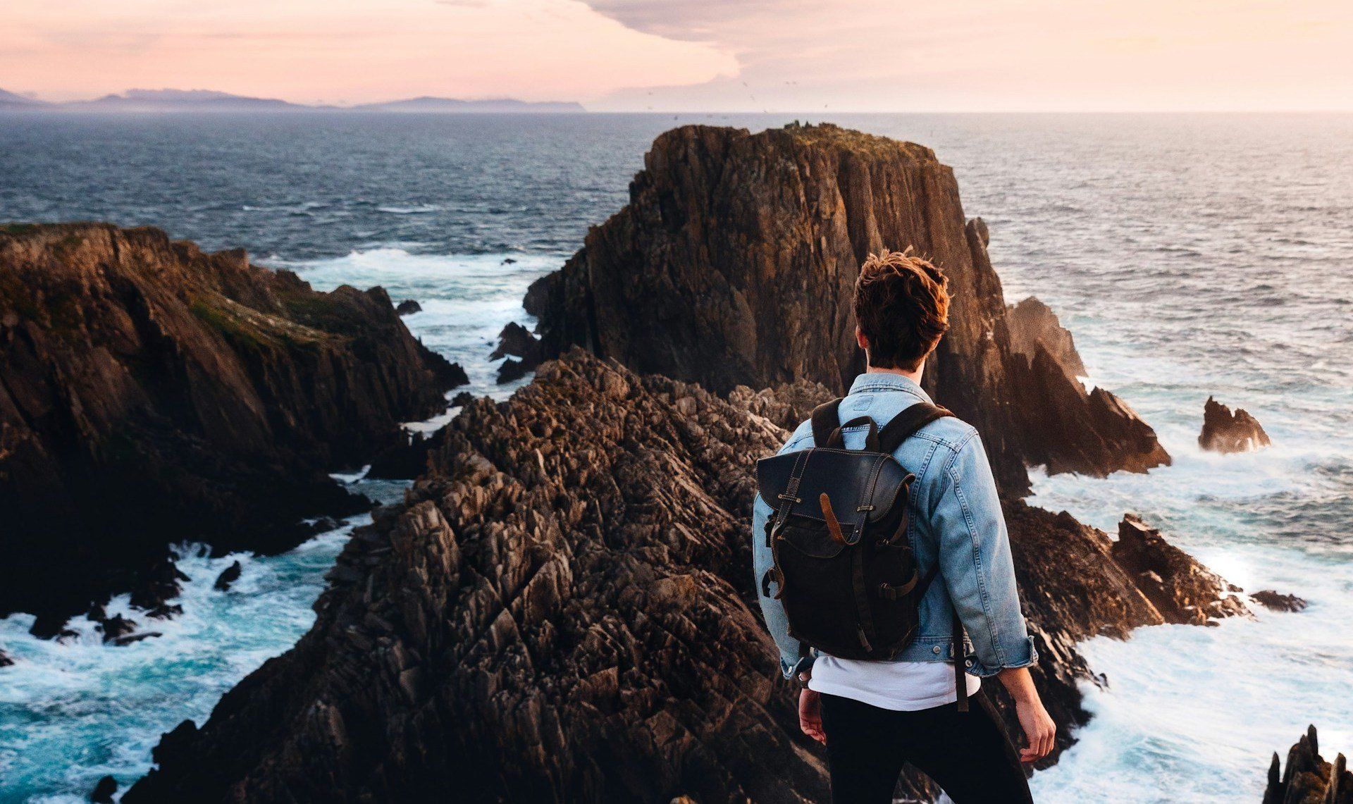 Malin-félsziget, az Ír-sziget legészakibb pontja, férfi áll a sziklák és a tenger előtt